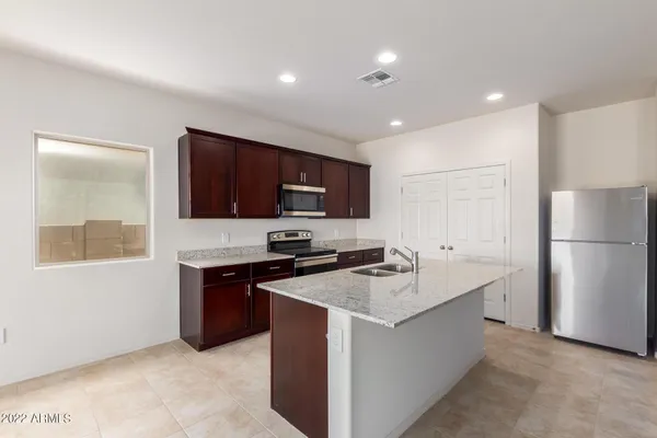 a kitchen with a sink a stove a refrigerator a center island and a window