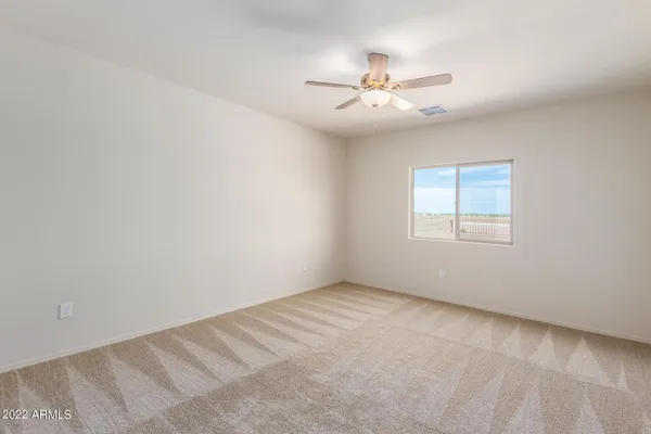 an empty room with windows and fan