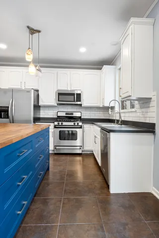 a kitchen with stainless steel appliances a sink stove and cabinets