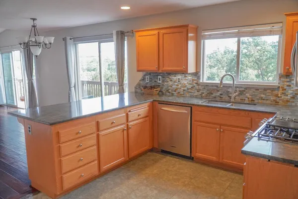 a kitchen with granite countertop a sink stove and cabinets