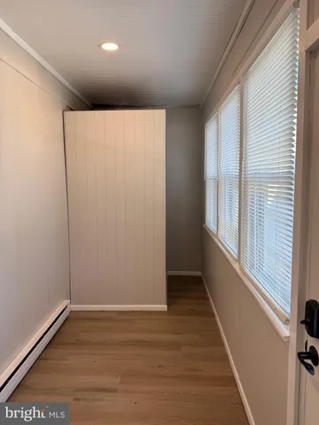 a view of a entryway with wooden floor and mirror