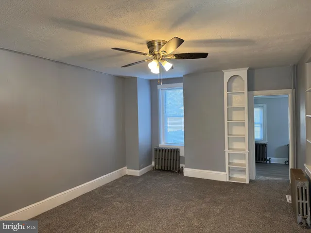 a view of an empty room with a ceiling fan