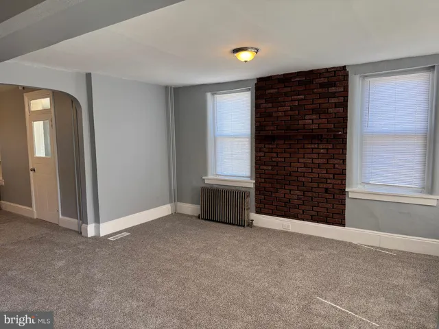 a view of an empty room with a fireplace and a window
