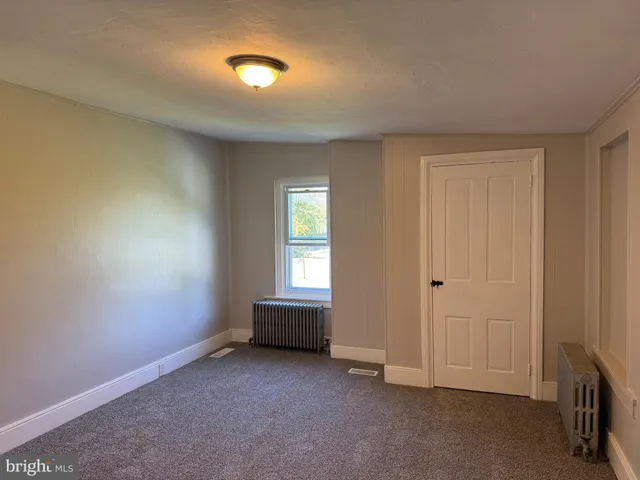 an empty room with windows and closet