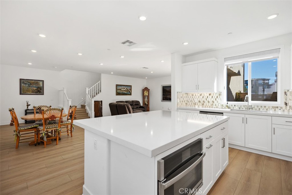 218 Sora Irvine, CA 92618 - Photo 27 of 65 a large white kitchen with lots of counter space and wooden floor