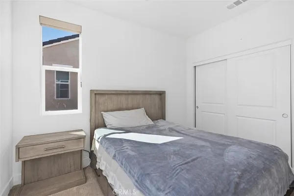 a spacious bedroom with a bed and a dresser