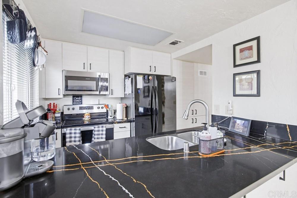 7861 Rancho Fanita Drive, Unit B Santee, CA 92071 - Photo 12 of 47 a kitchen with kitchen island granite countertop a sink appliances cabinets and a counter top space
