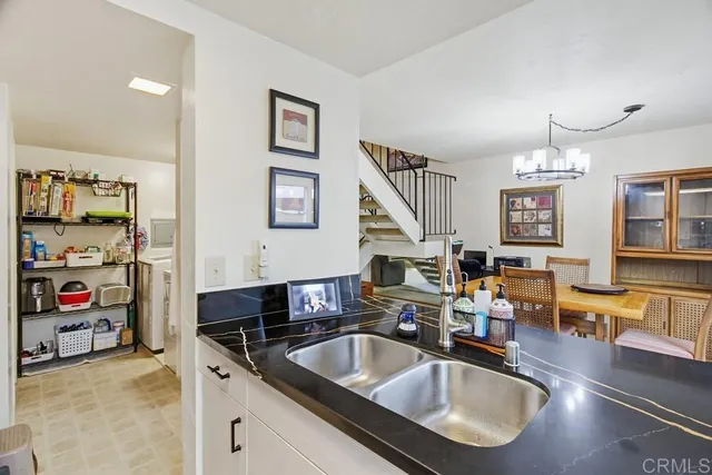 a kitchen island with granite countertop a sink and a refrigerator