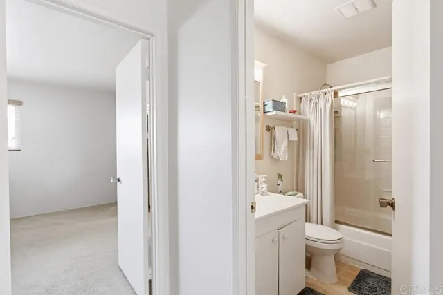 a bathroom with a granite countertop toilet a sink and a mirror