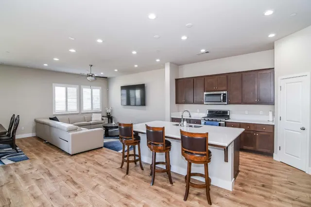 a kitchen with stainless steel appliances kitchen island granite countertop a sink and a refrigerator