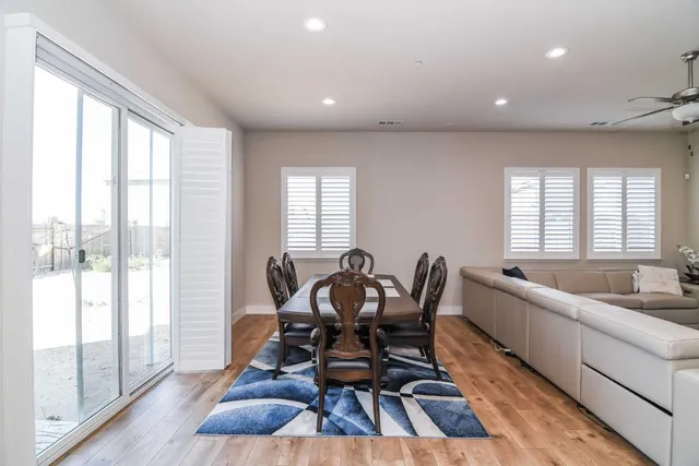 a living room with stainless steel appliances kitchen island granite countertop furniture and a wooden floor