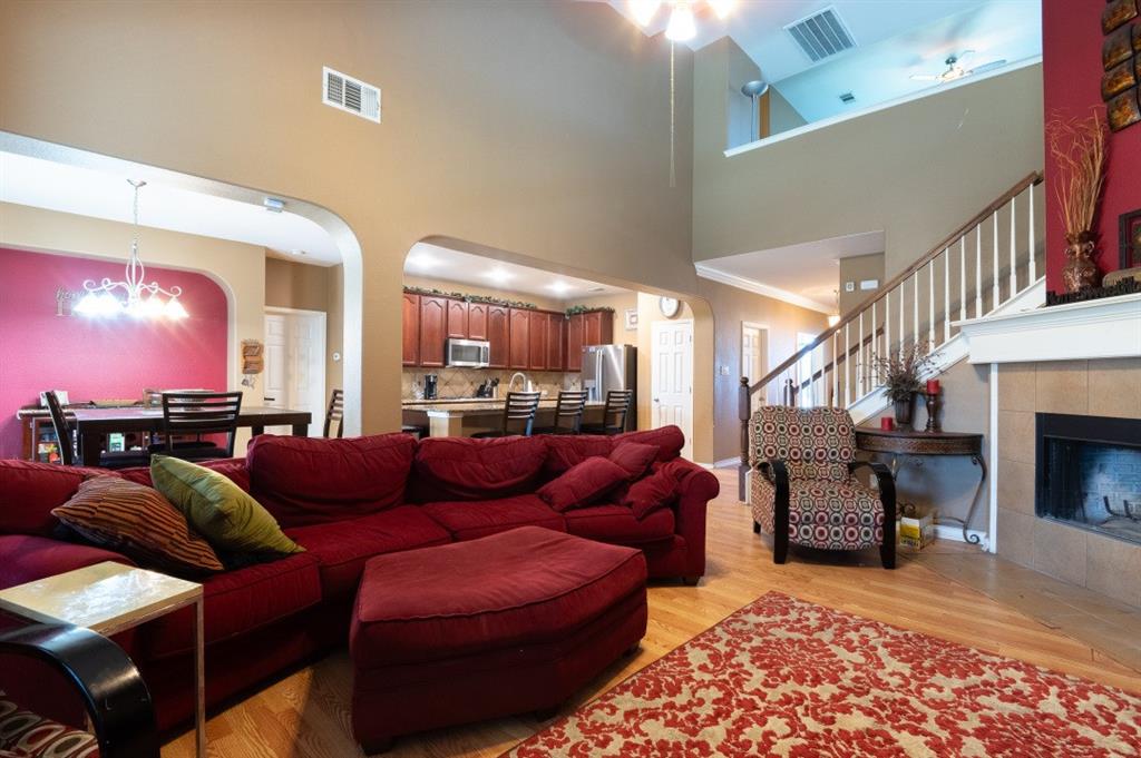 2248 Condor Street Grand Prairie, TX 75052 - Photo 19 of 25 a living room with furniture a fireplace and a chandelier