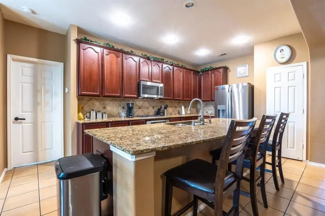 a kitchen with a table chairs sink refrigerator and cabinets