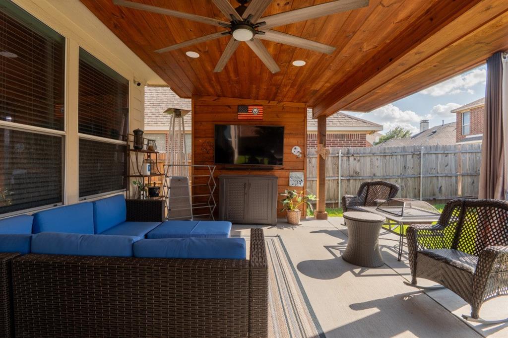 2248 Condor Street Grand Prairie, TX 75052 - Photo 24 of 25 a living room with furniture a flat screen tv and a table
