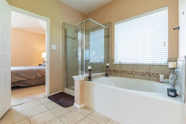 a bathroom with a tub a sink and a window