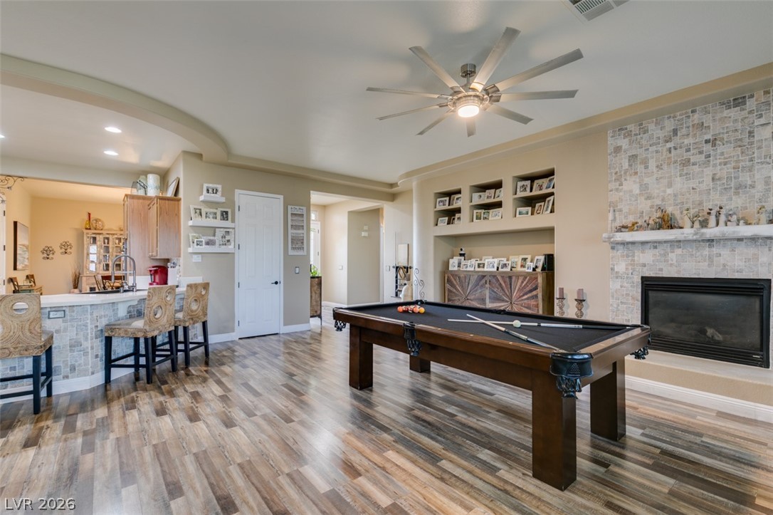 7524 Midnight Rambler Street Las Vegas, NV 89149 - Photo 11 of 51 Natural wood flooring complements the open-concept living area and stone fireplace.