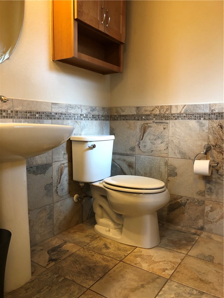 1303 Casey Street, Unit A Austin, TX 78745 - Photo 10 of 16 a bathroom with a toilet a sink and a mirror