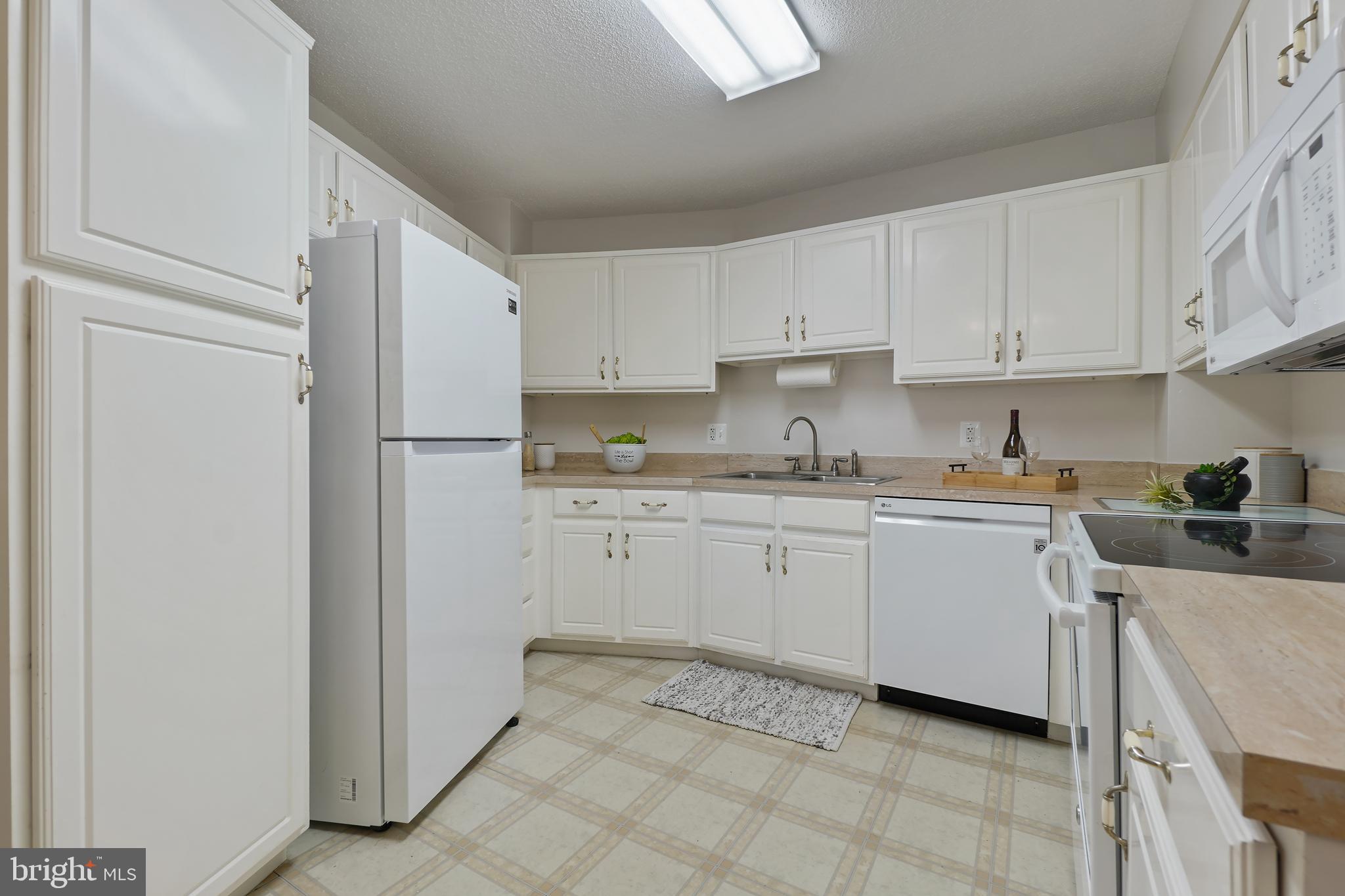 14801 Pennfield Circle, Unit 306 Silver Spring, MD 20906 - Photo 12 of 45 a kitchen with cabinets and a refrigerator