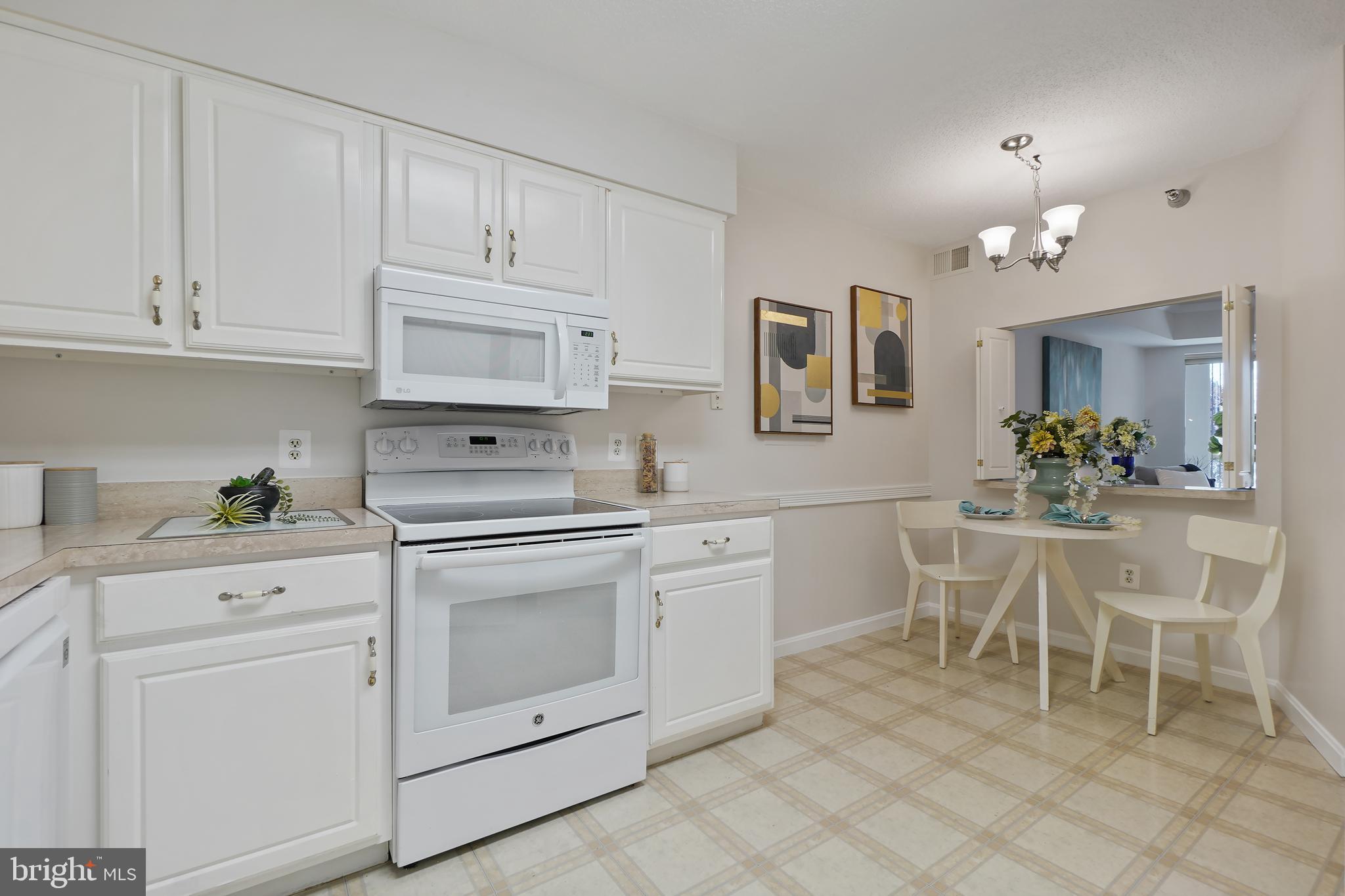 14801 Pennfield Circle, Unit 306 Silver Spring, MD 20906 - Photo 13 of 45 a kitchen with white cabinets and appliances