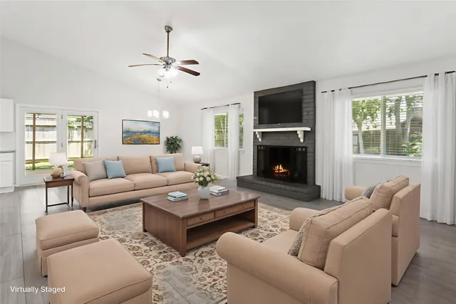 a living room with furniture a flat screen tv and a fireplace