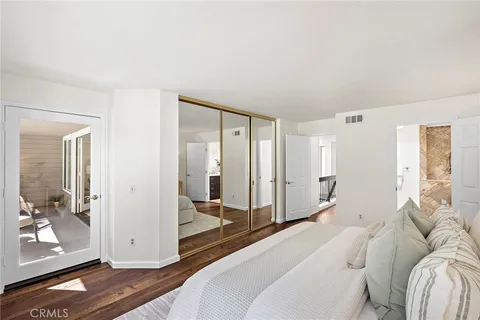 a spacious bedroom with a bed and glass door