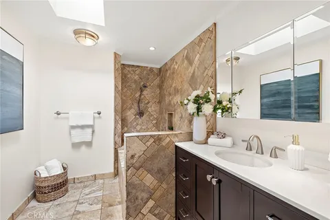 a bathroom with a granite countertop sink a toilet and shower