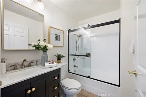 a bathroom with a granite countertop sink toilet a mirror a vanity and shower