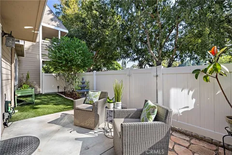 a view of a patio with couches and a fire pit and large trees