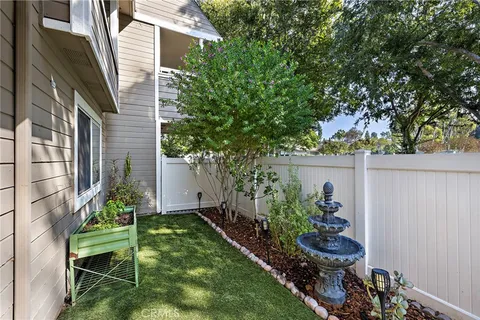 a view of a chair and table in backyard of the house