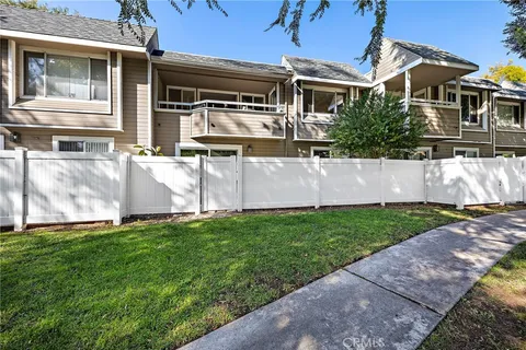 a view of a house with a yard and a large tree