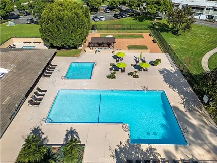 an aerial view of a tennis ground and a cars park side of the road