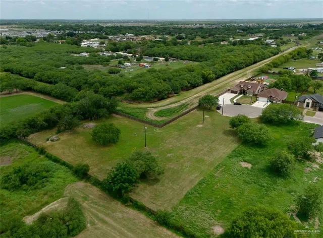 an aerial view of residential houses with outdoor space and trees