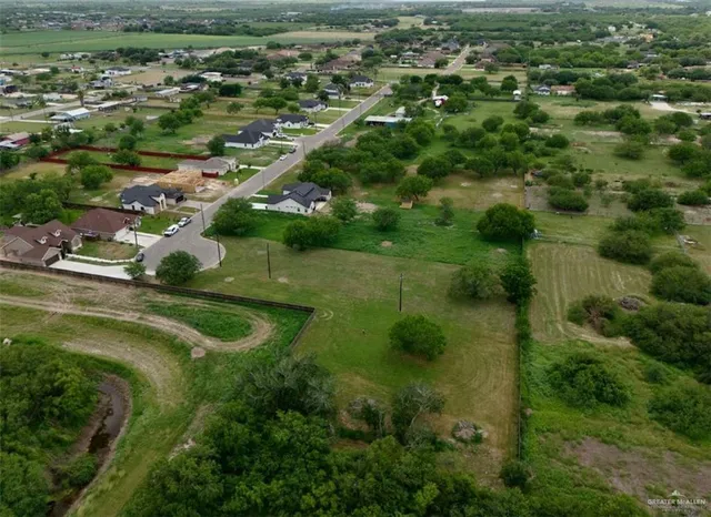 an aerial view of residential houses with outdoor space and trees