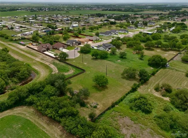 an aerial view of residential houses with outdoor space and trees