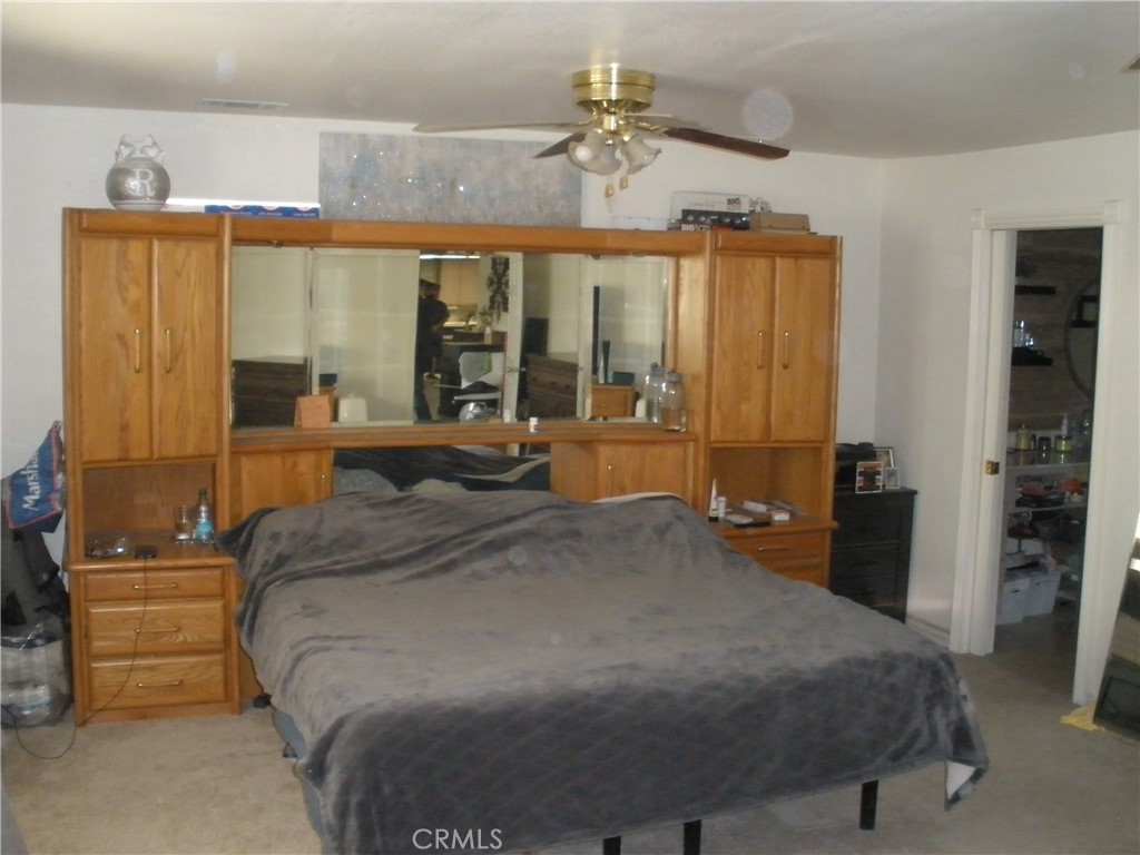 39036 Sage Road Lucerne Valley, CA 92356 - Photo 12 of 41 a bedroom with a large bed and a chandelier