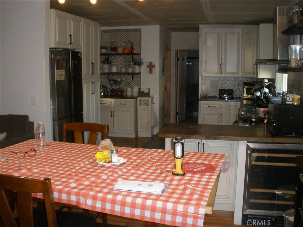 39036 Sage Road Lucerne Valley, CA 92356 - Photo 29 of 41 a kitchen with stainless steel appliances wooden floor dining table and chairs