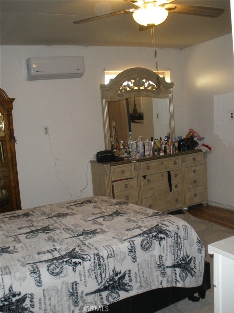 39036 Sage Road Lucerne Valley, CA 92356 - Photo 30 of 41 a bedroom with a large bed and a chandelier