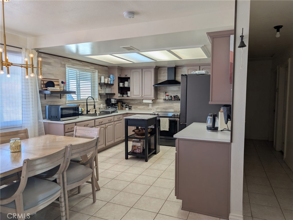 39036 Sage Road Lucerne Valley, CA 92356 - Photo 6 of 41 a kitchen with kitchen island a dining table chairs cabinets and a counter top space