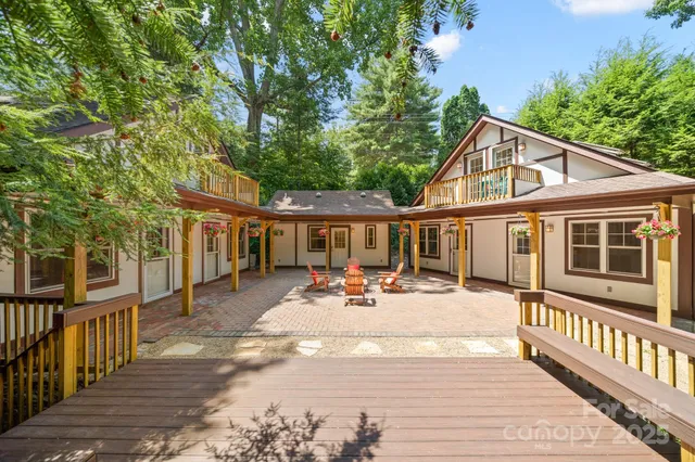 a view of a house with wooden deck and furniture