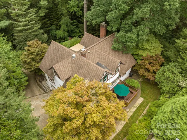 an aerial view of a house with swimming pool and garden