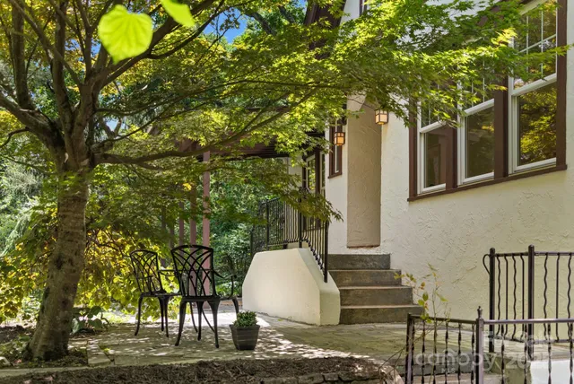 a view of backyard with wooden fence and large trees