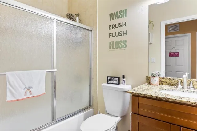 a bathroom with a granite countertop sink toilet and a mirror