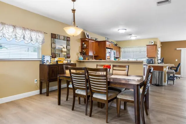 a dining area with a table chairs and a kitchen view