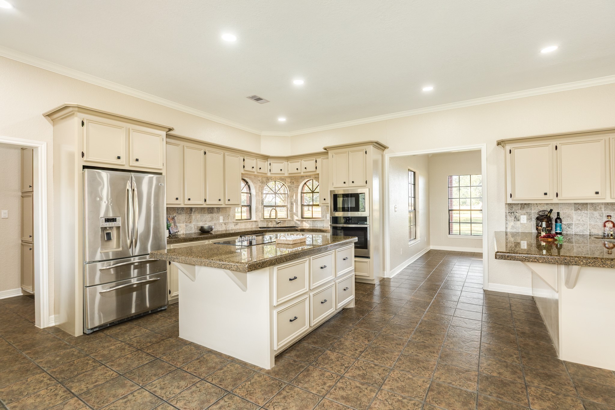 310 County Road 47 Angleton, TX 77515 - Photo 25 of 50 a kitchen with stainless steel appliances kitchen island granite countertop a refrigerator and a stove top oven
