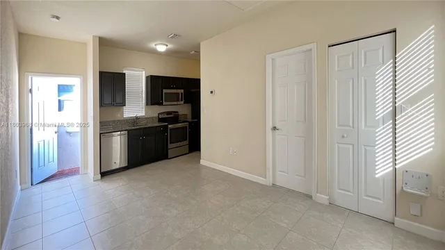 a view of kitchen with stainless steel appliances granite countertop a refrigerator and a sink