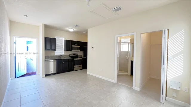 a large kitchen with a sink and stainless steel appliances