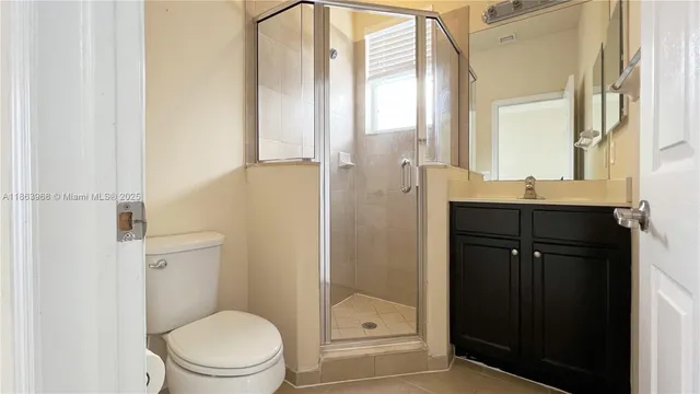 a bathroom with a granite countertop sink a toilet and shower