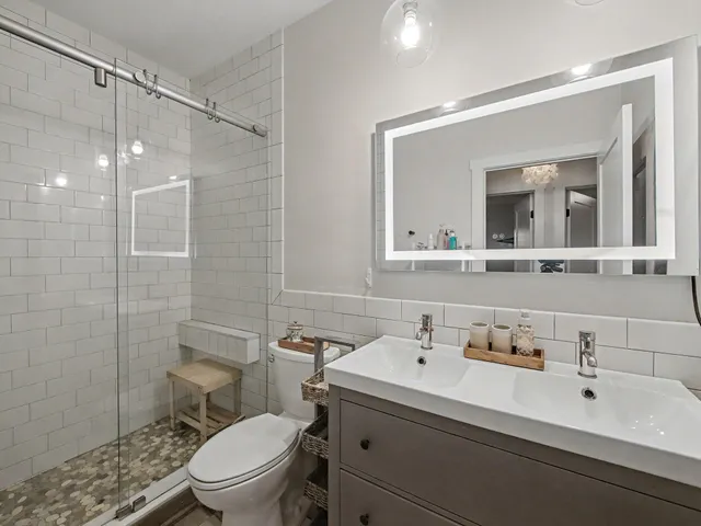 a bathroom with a sink toilet a mirror and shower