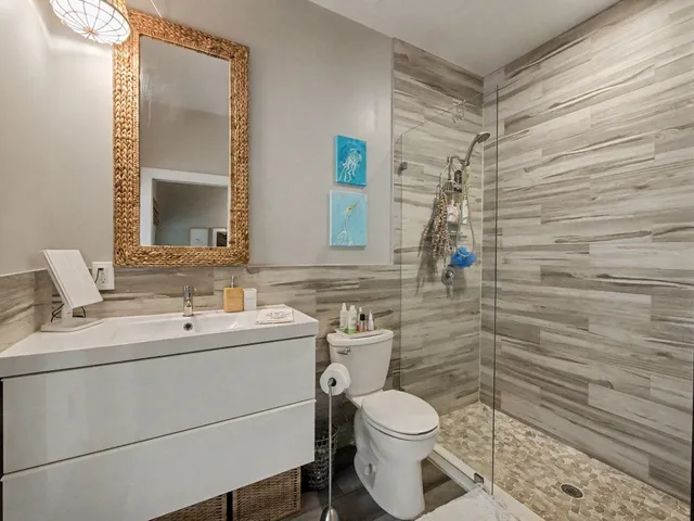 a bathroom with a toilet sink vanity and mirror