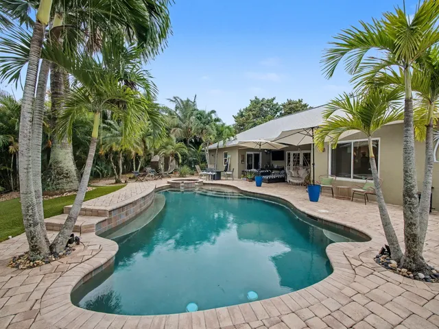 a view of a house with swimming pool and sitting area